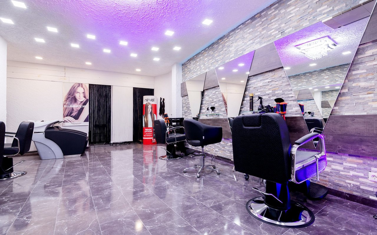 Kappersstoel en wasplaatsen in de salon, met paarse ledverlichting aan het plafond